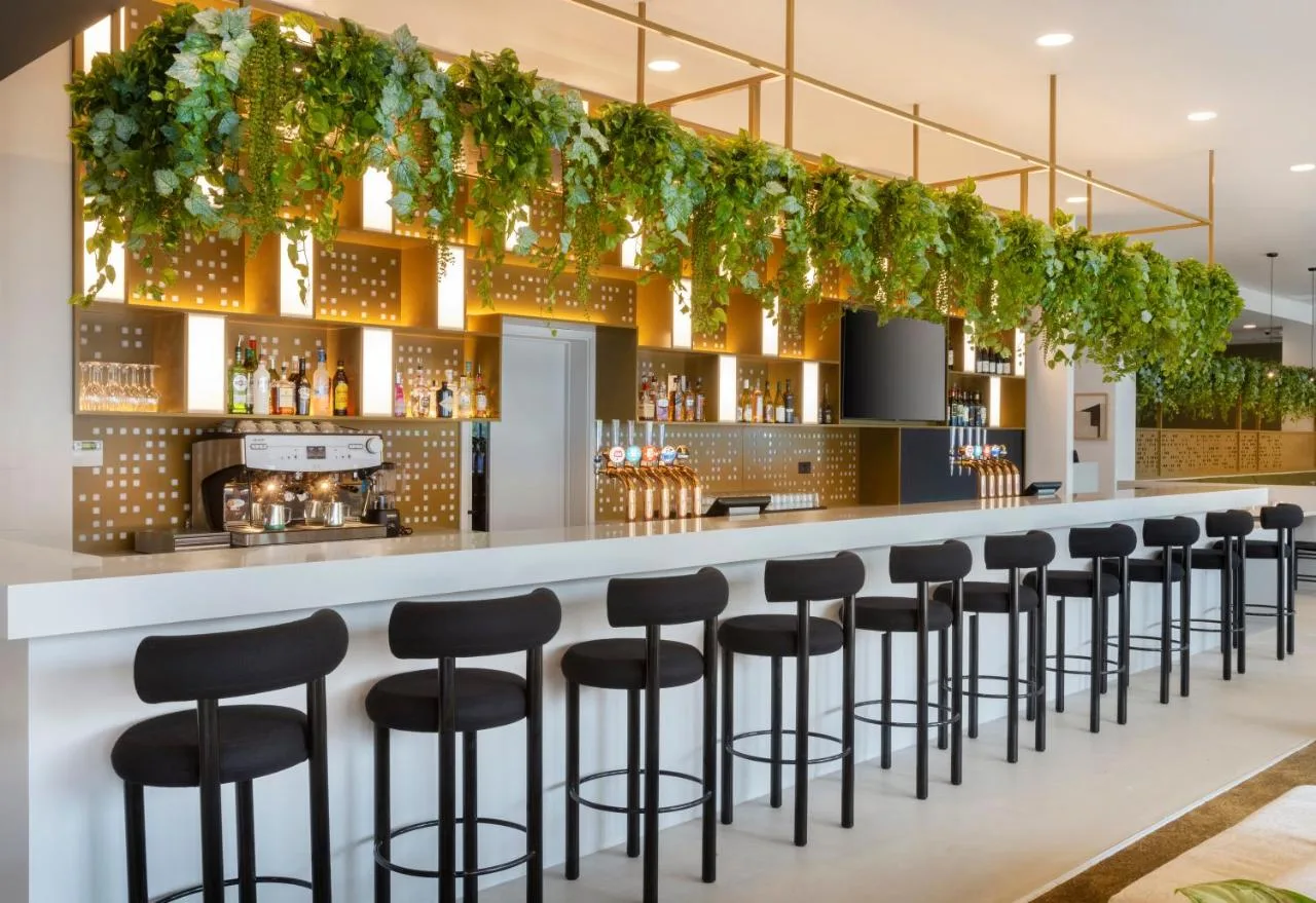 a bar with black stools in a restaurant at Leonardo Hotel Manchester Piccadilly in Manchester