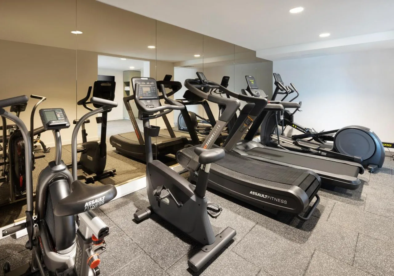 a gym with many cardio machines in a room at Leonardo Hotel Manchester Piccadilly in Manchester